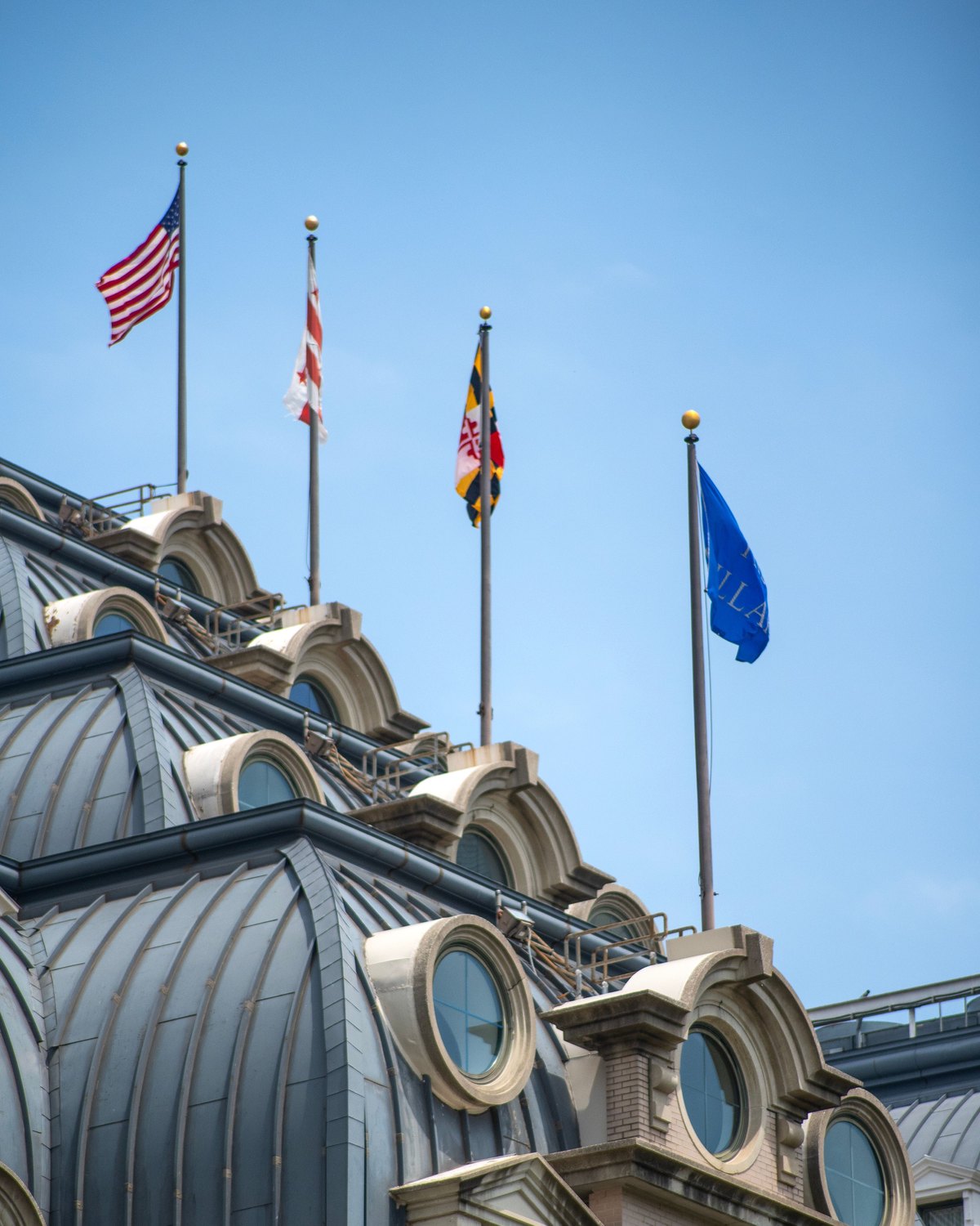 A row of flags on a rooftop